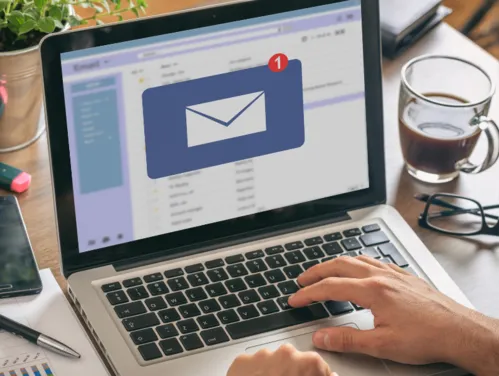 Person working at laptop open to email screen.