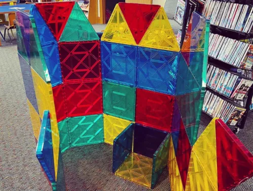 STEM Kit in use featuring a structure built out of large magnetic tiles in a library.