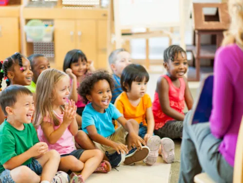 Group of young children being read a story by a librarian.