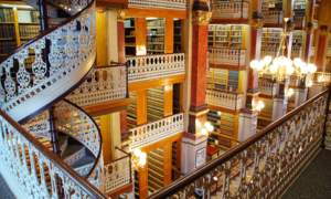 Interior of the Law Library from one of the middle tiers, looking across at the wrought iron balustrades and wooden shelving filled with books.