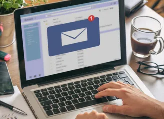 Person working at laptop open to email screen.