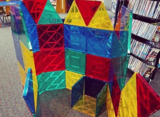 STEM Kit in use featuring a structure built out of large magnetic tiles in a library.