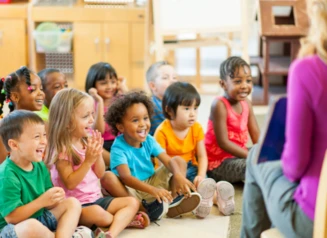 Group of young children being read a story by a librarian.
